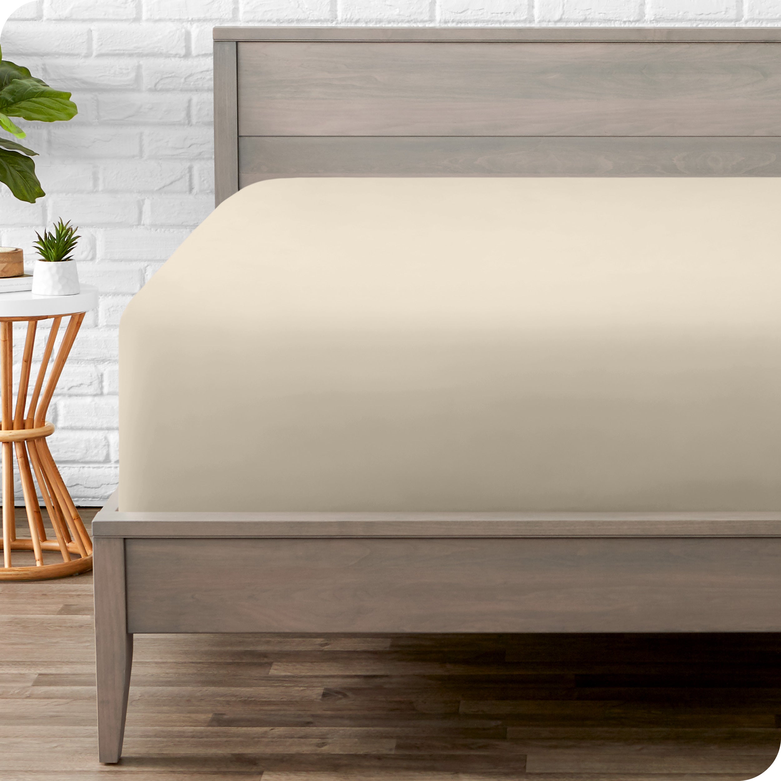 A modern bed with a fitted microfiber sheet on it
