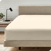 A bed with a microfiber fitted sheet on the mattress. 