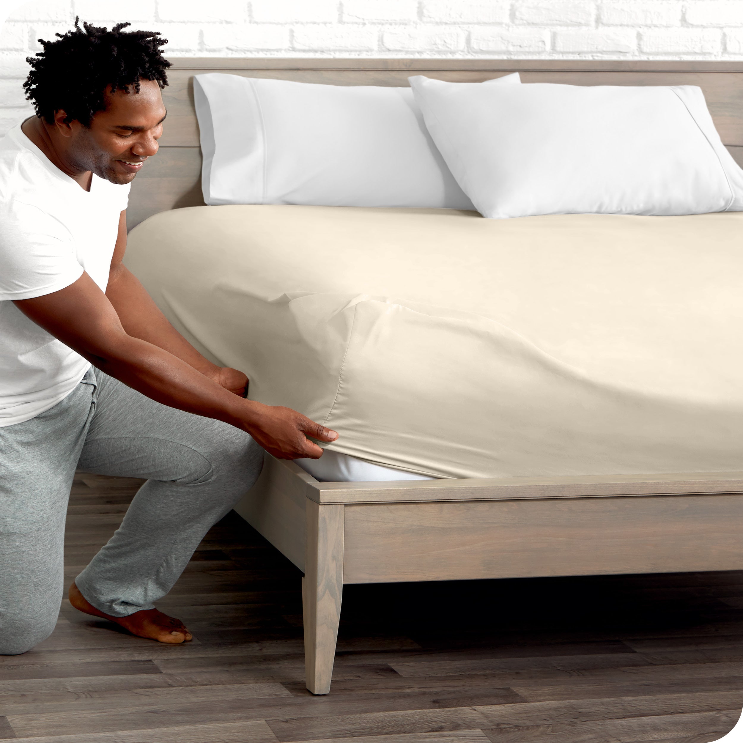 A man putting the microfiber fitted sheet on a mattress. 
