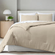 A comforter set on a bed in a bright modern room