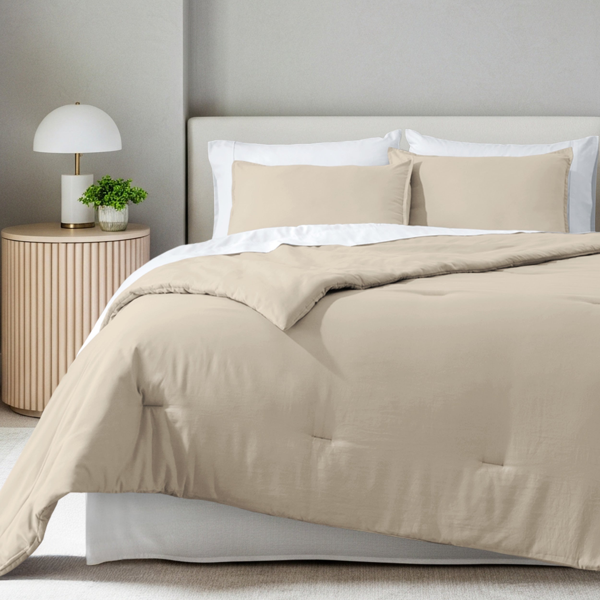 A comforter set on a bed in a bright modern room