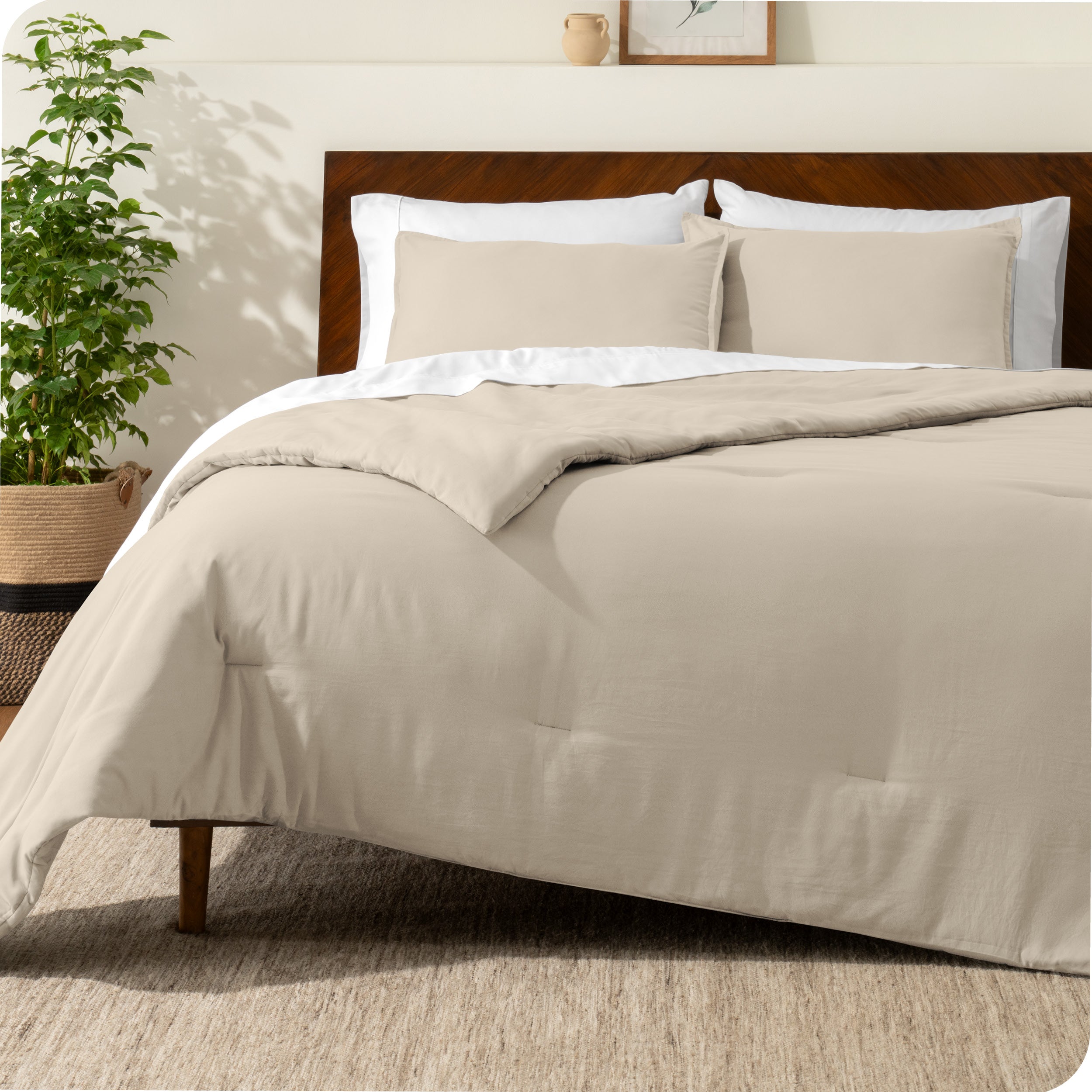 A comforter set on a bed with a dark wooden headboard