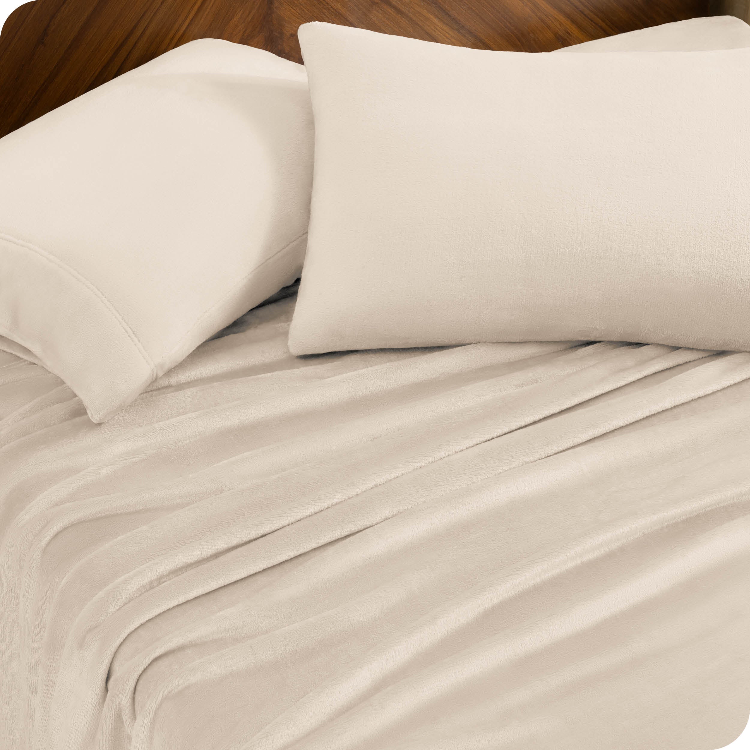 Two pillows with pillowcases on them set on a bed with matching sheets