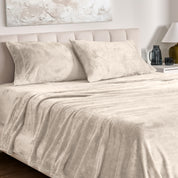 Microplush bed sheets and pillowcases on a bed with a neutral headboard and decor.