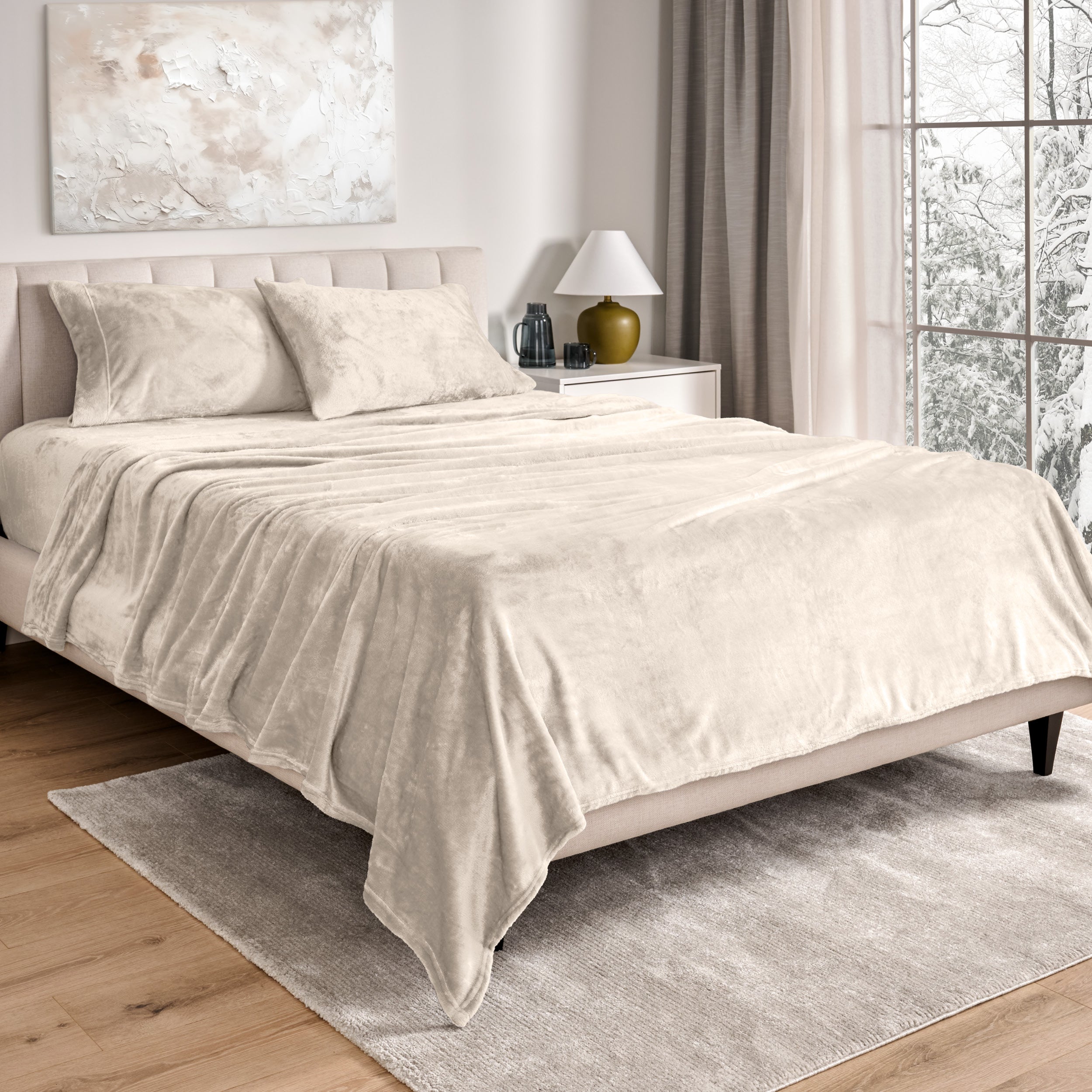 Sheets and matching pillowcases on a bed in a bedroom with a lamp and window in the background.
