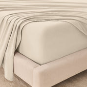 Organic flannel sheets on a beige bed frame
