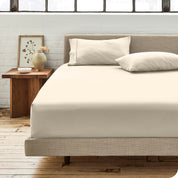 Percale fitted sheet on a mattress with matching pillowcases on pillows