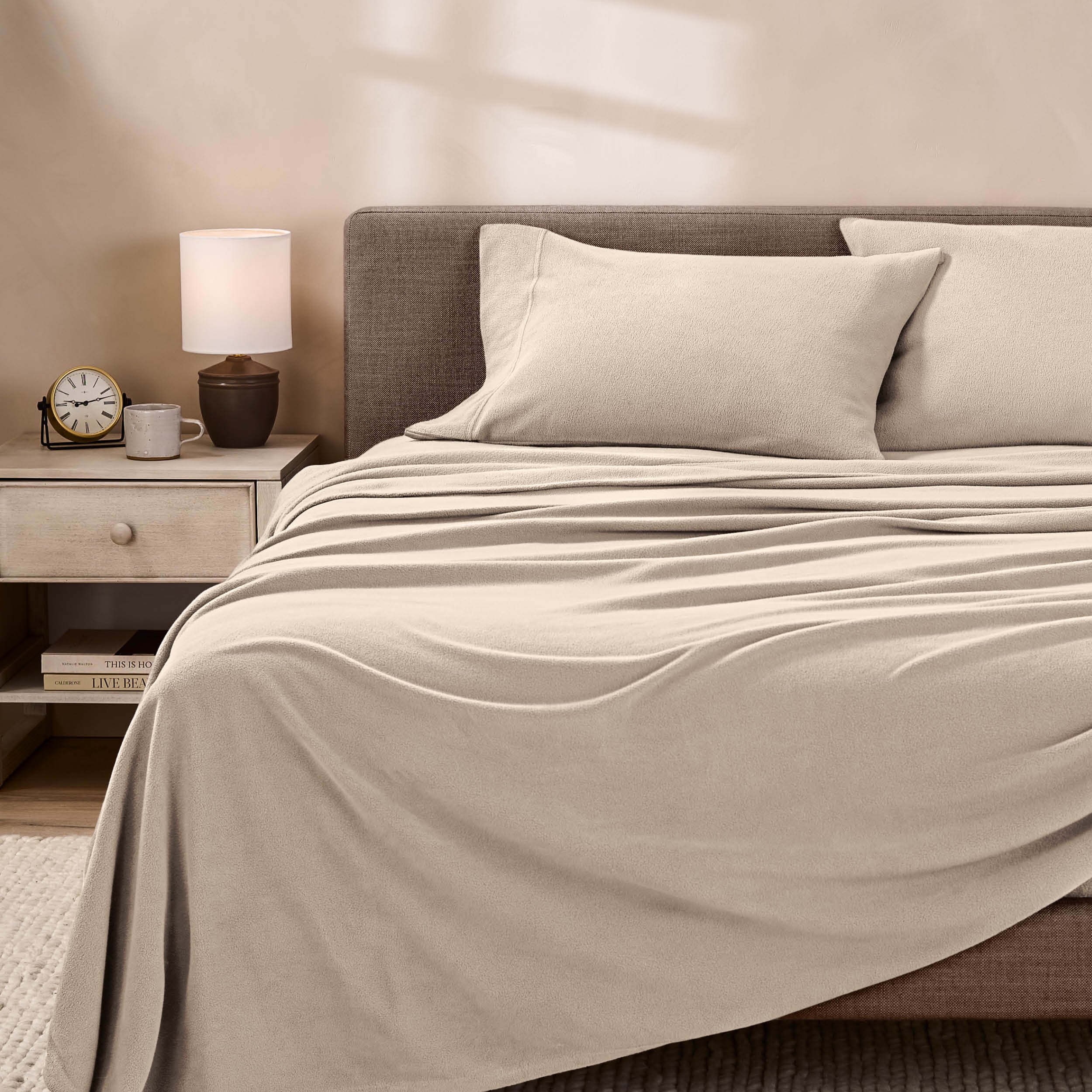 View of fleece sheets from the end of a bed with the top sheet draped over the side and end