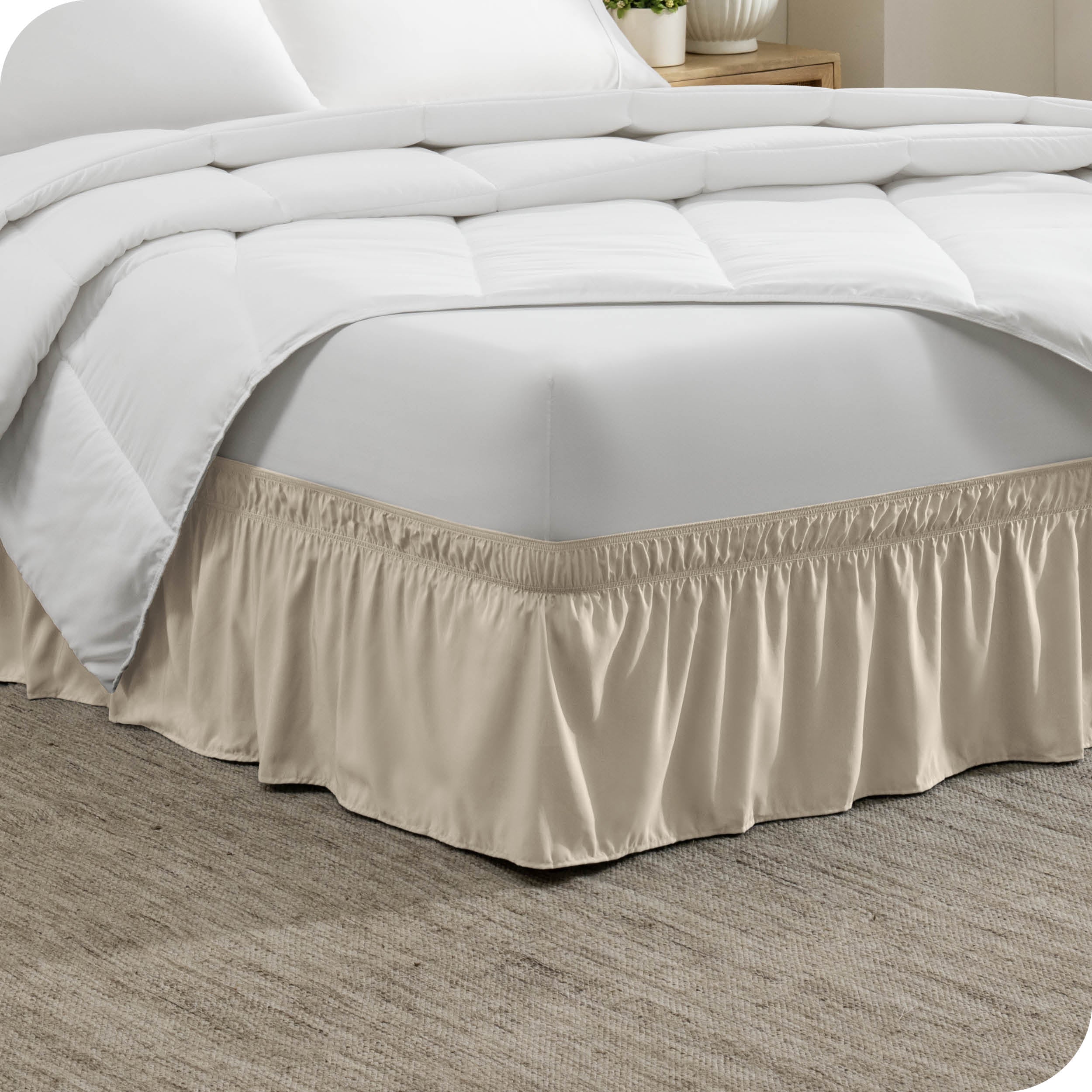 The corner of a bed with a polyester bed skirt on it