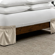 The adjustable elastic belt of a bed skirt wrapped around the mattress