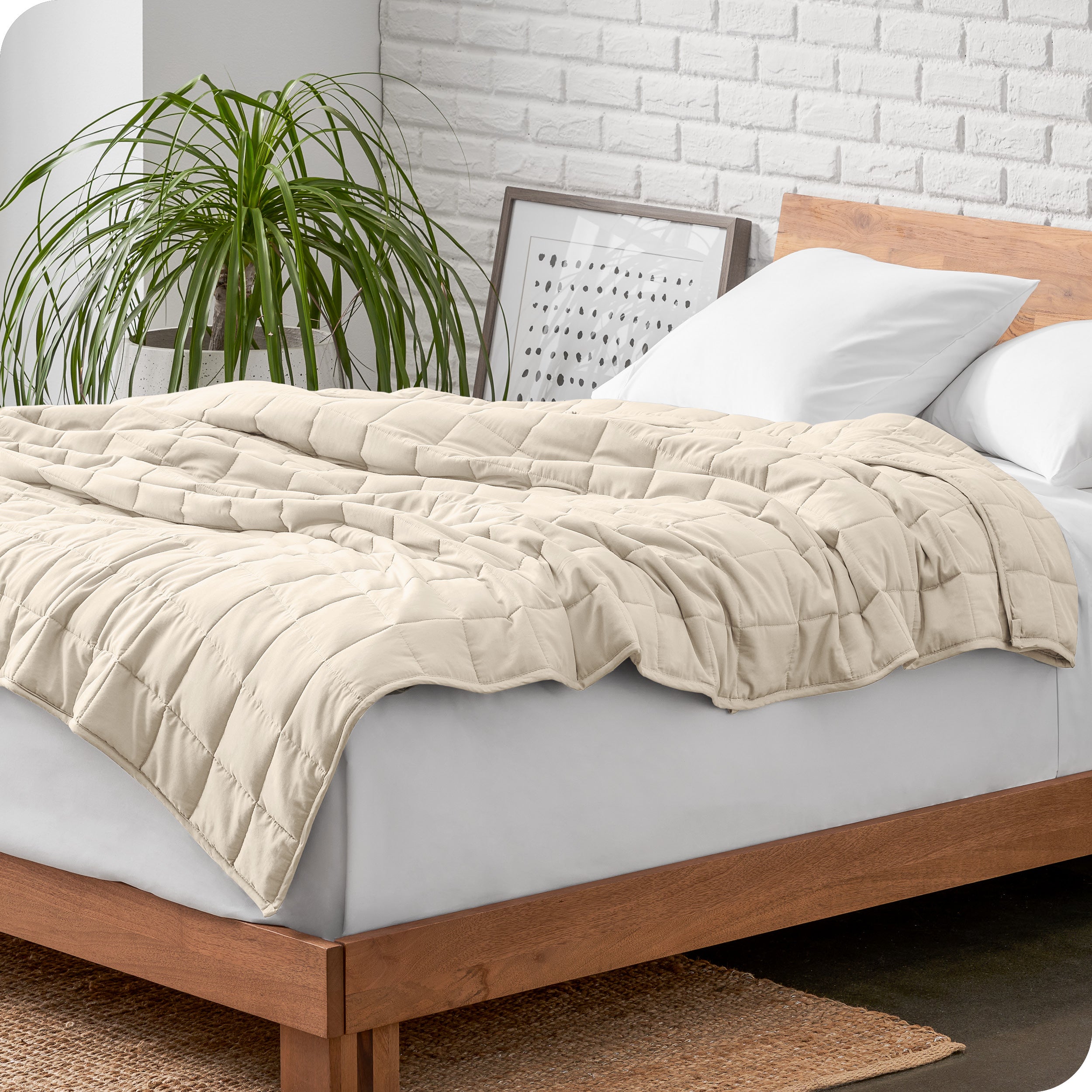 A cotton weighted blanket is loosely draped over a bed