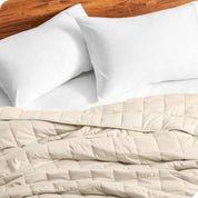 Close up of a weighted blanket on a bed with  2 pillows