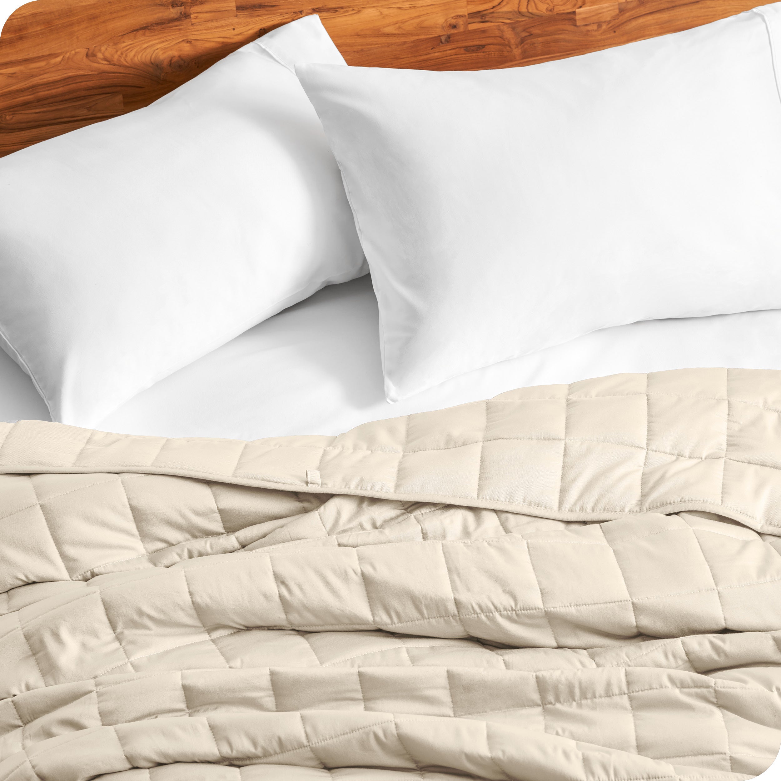 Close up of a weighted blanket on a bed with  2 pillows