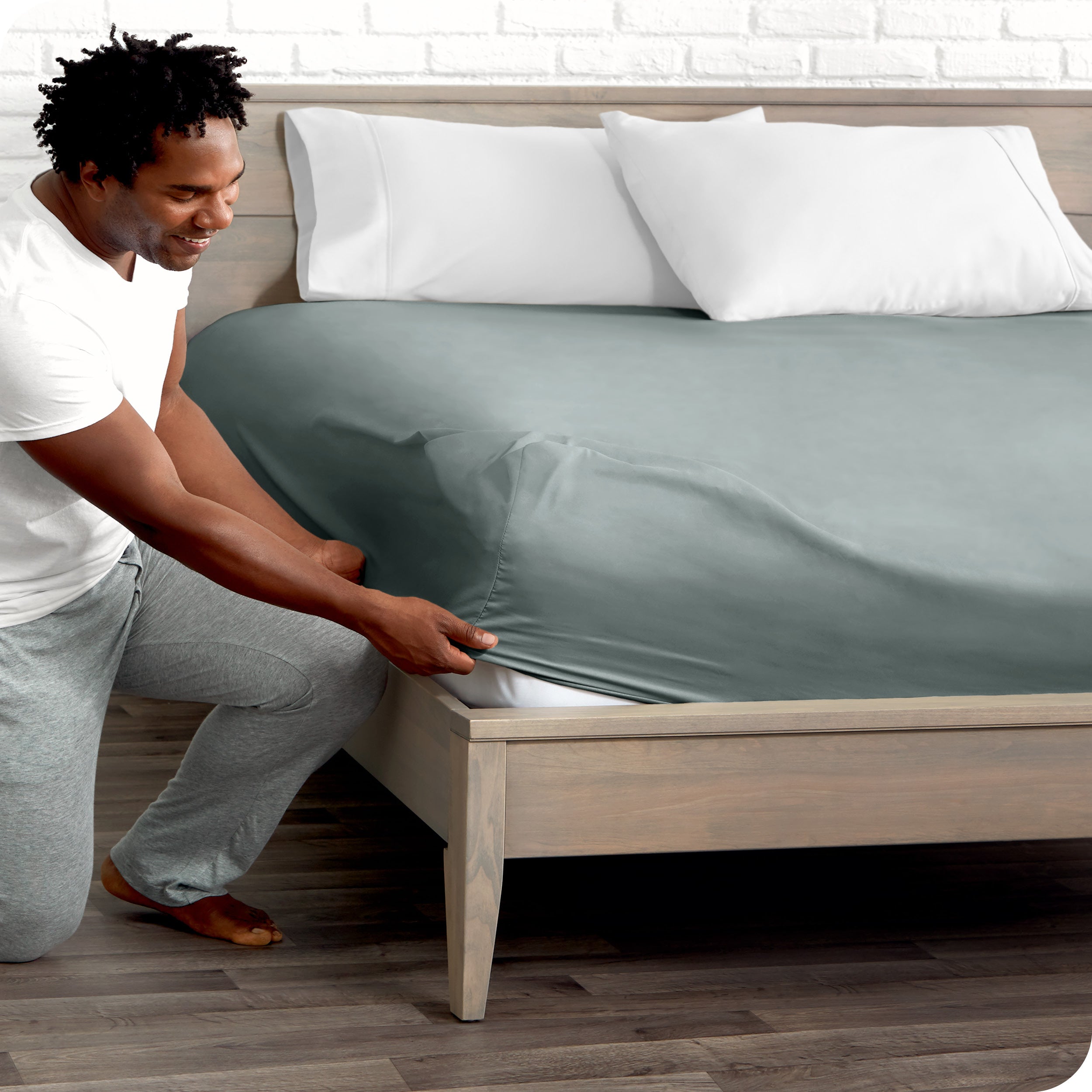 A man putting the microfiber fitted sheet on a mattress. 