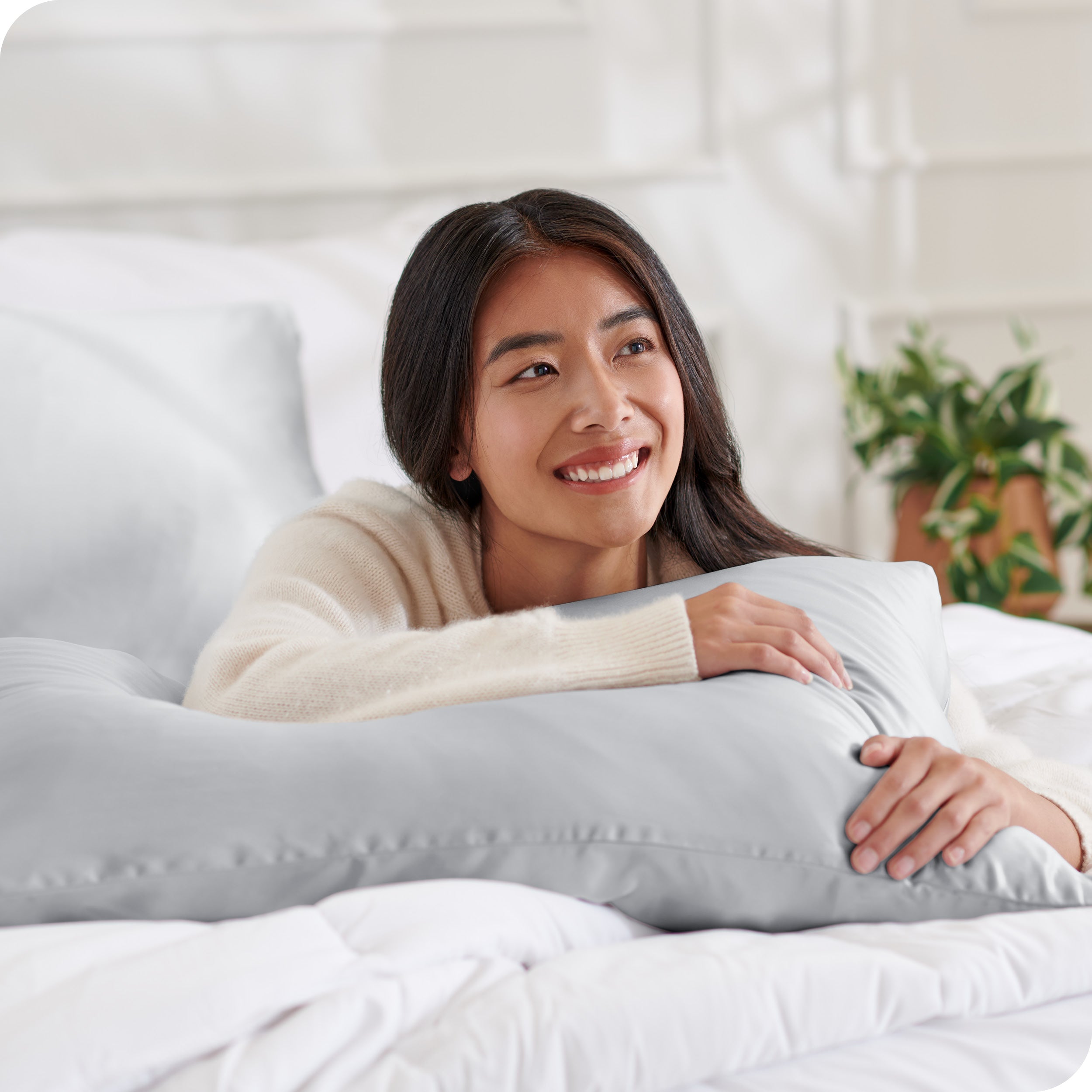 A woman on a bed with her arm resting on a pillow