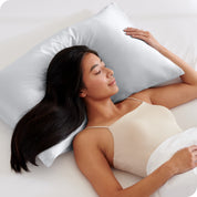 A woman sleeping with her head on a pillow with a silk pillowcase on it