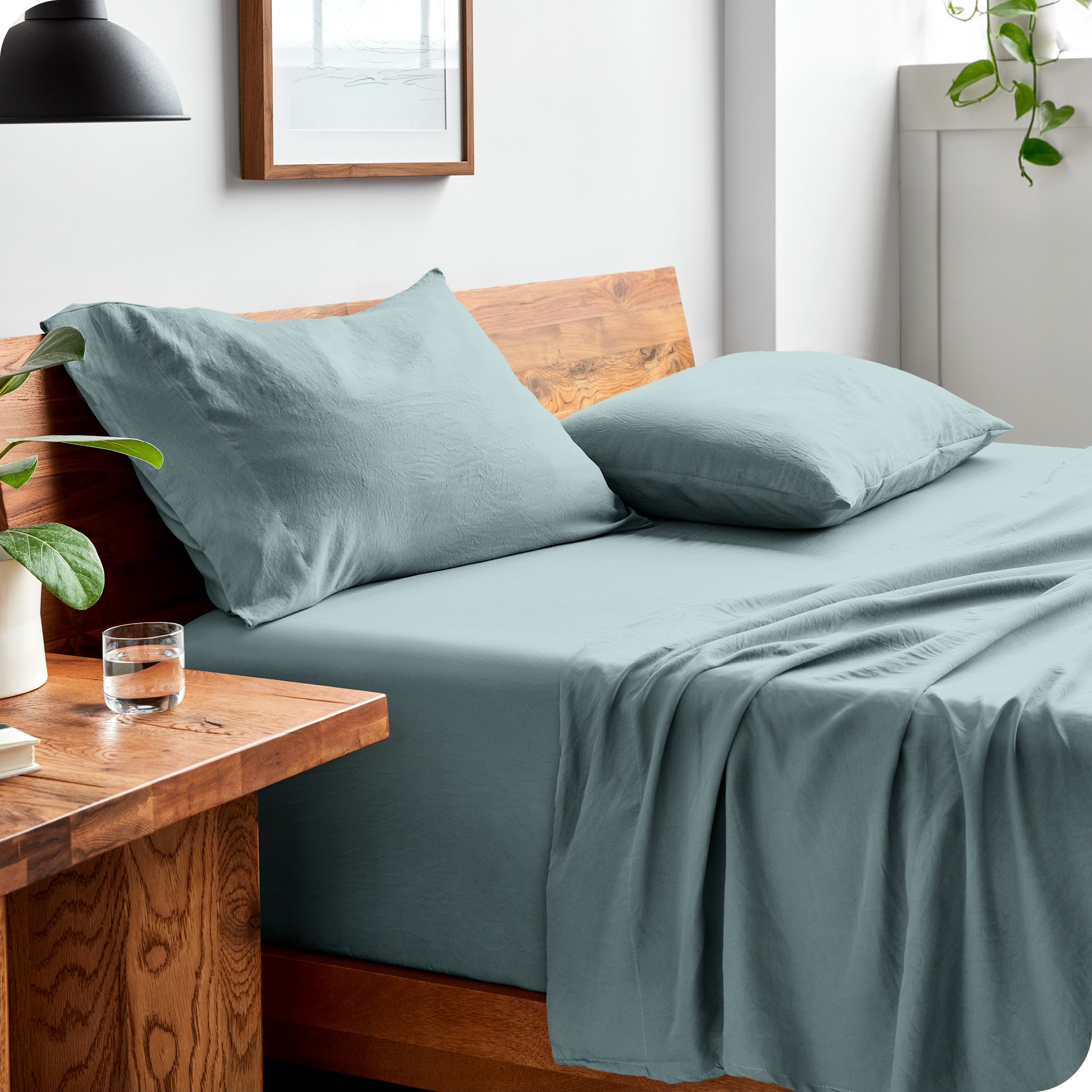 Side view of bed made with fitted sheet, pillowcases, and top sheet