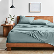 Modern bedroom with Sandwashed sheets draped over the end and side of mattress
