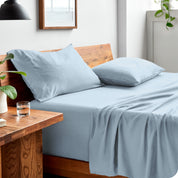 Side view of bed made with fitted sheet, pillowcases, and top sheet