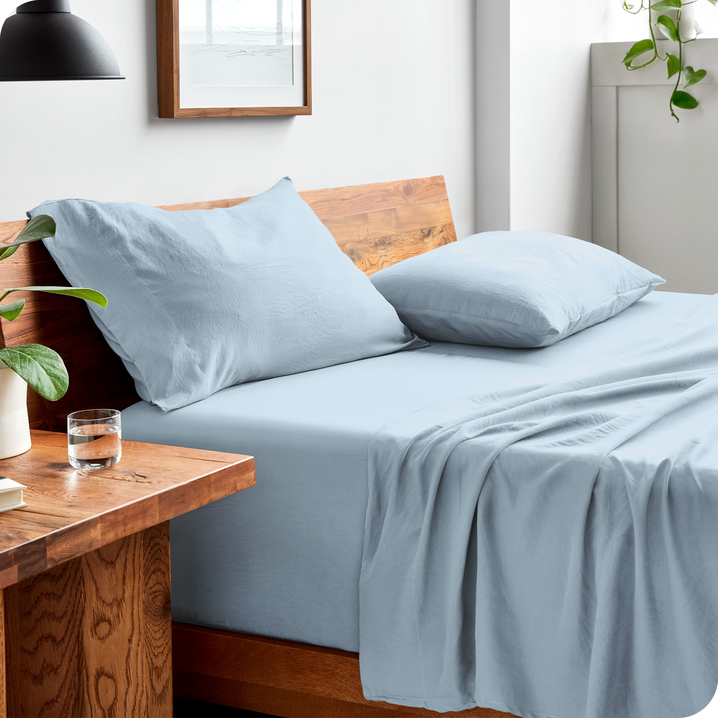 Side view of bed made with fitted sheet, pillowcases, and top sheet