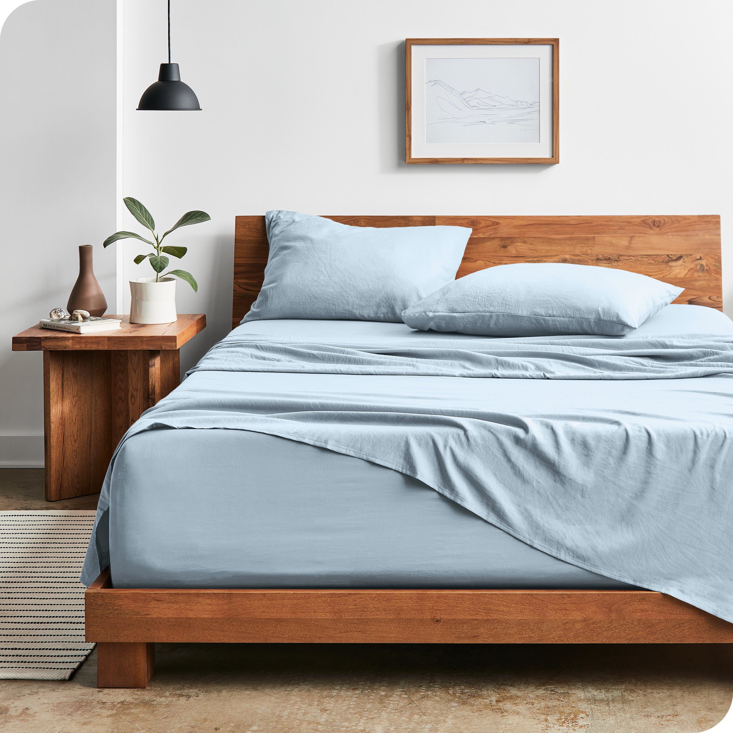 Modern bedroom with Sandwashed sheets draped over the end and side of mattress
