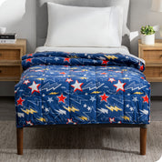 A printed weighted blanket hanging off the end of a twin size bed