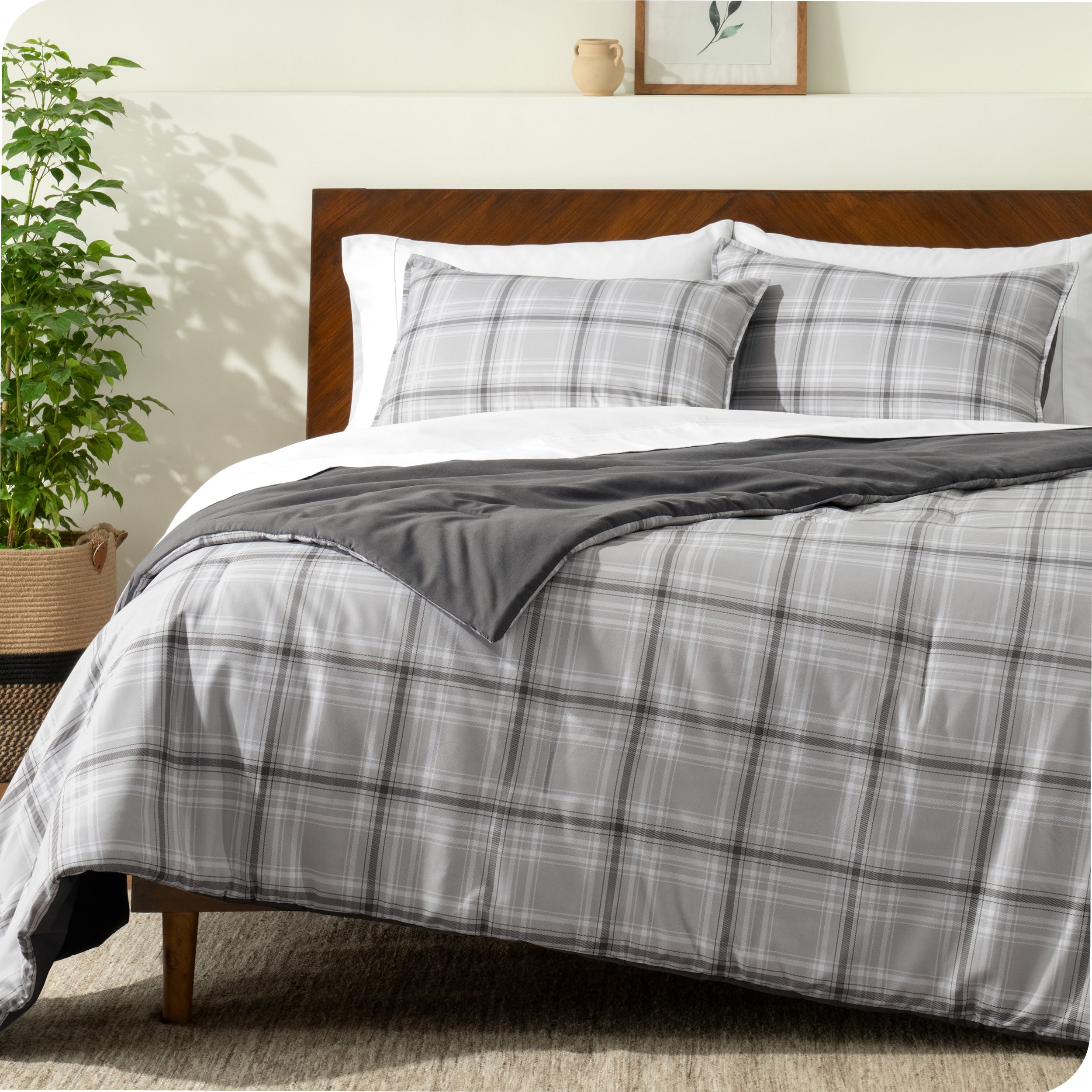 A comforter set on a bed with a dark wooden headboard