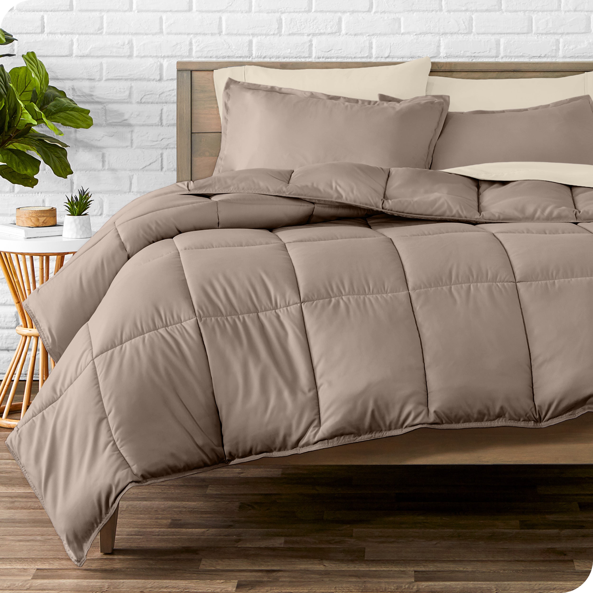 A wooden bed frame with sheets, pillow shams and a comforter on the bed