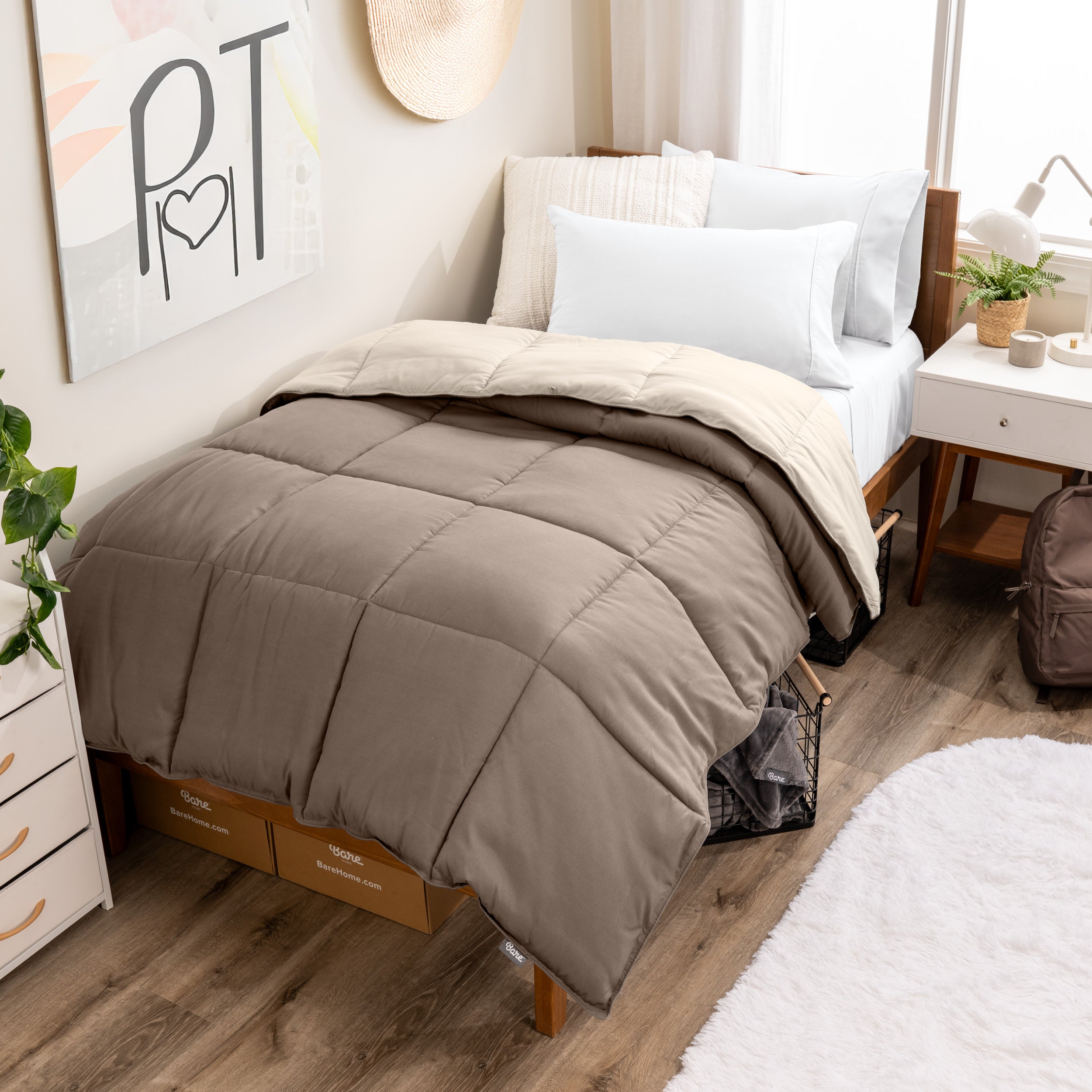 Wooden bed frame with a reversible comforter on the bed. The comforter is folded back over showing the two different colors.