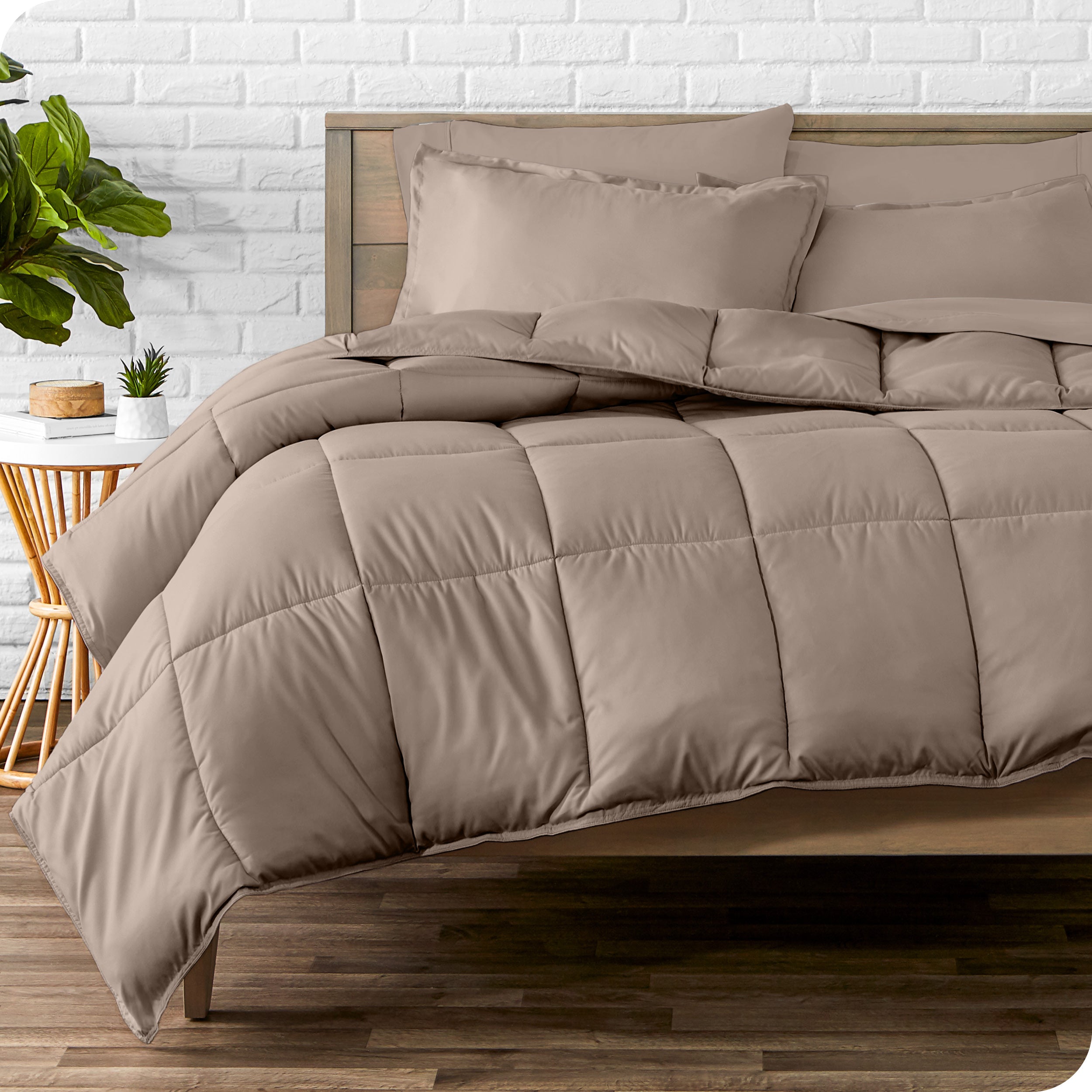 A wooden bed frame with sheets, pillow shams and a comforter on the bed