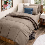 A college dorm room with a bed in a bag set on the mattress
