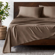 Wooden bed frame with bamboo sheets on the bed
