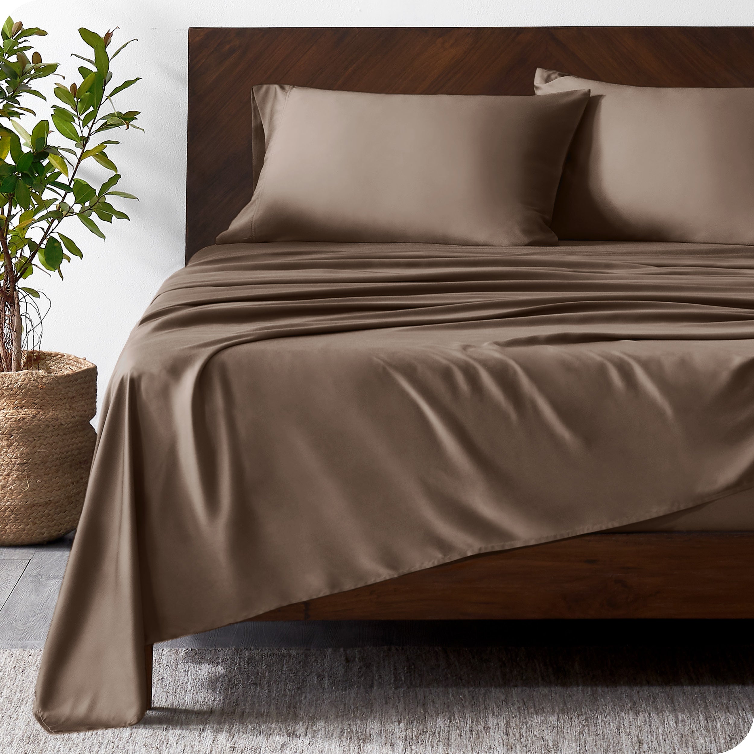 Wooden bed frame with bamboo sheets on the bed