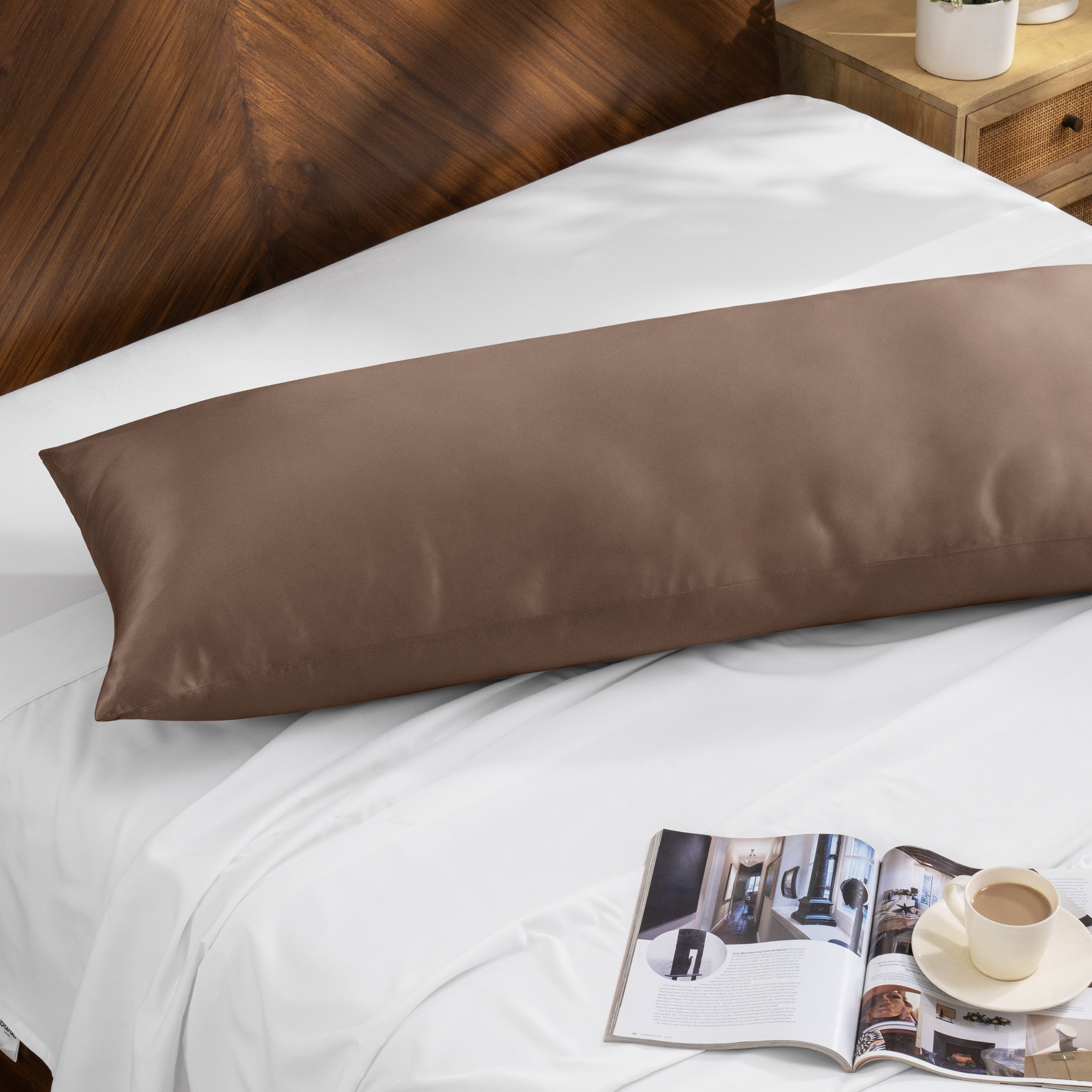 Bamboo body pillow on a bed with a magazine and cup of coffee nearby.
