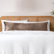 Bamboo body pillowcase on a bed with white bedding and a wicker headboard.