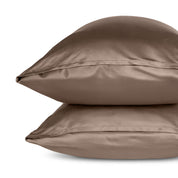 Two pillows with pillowcases stacked on a white background