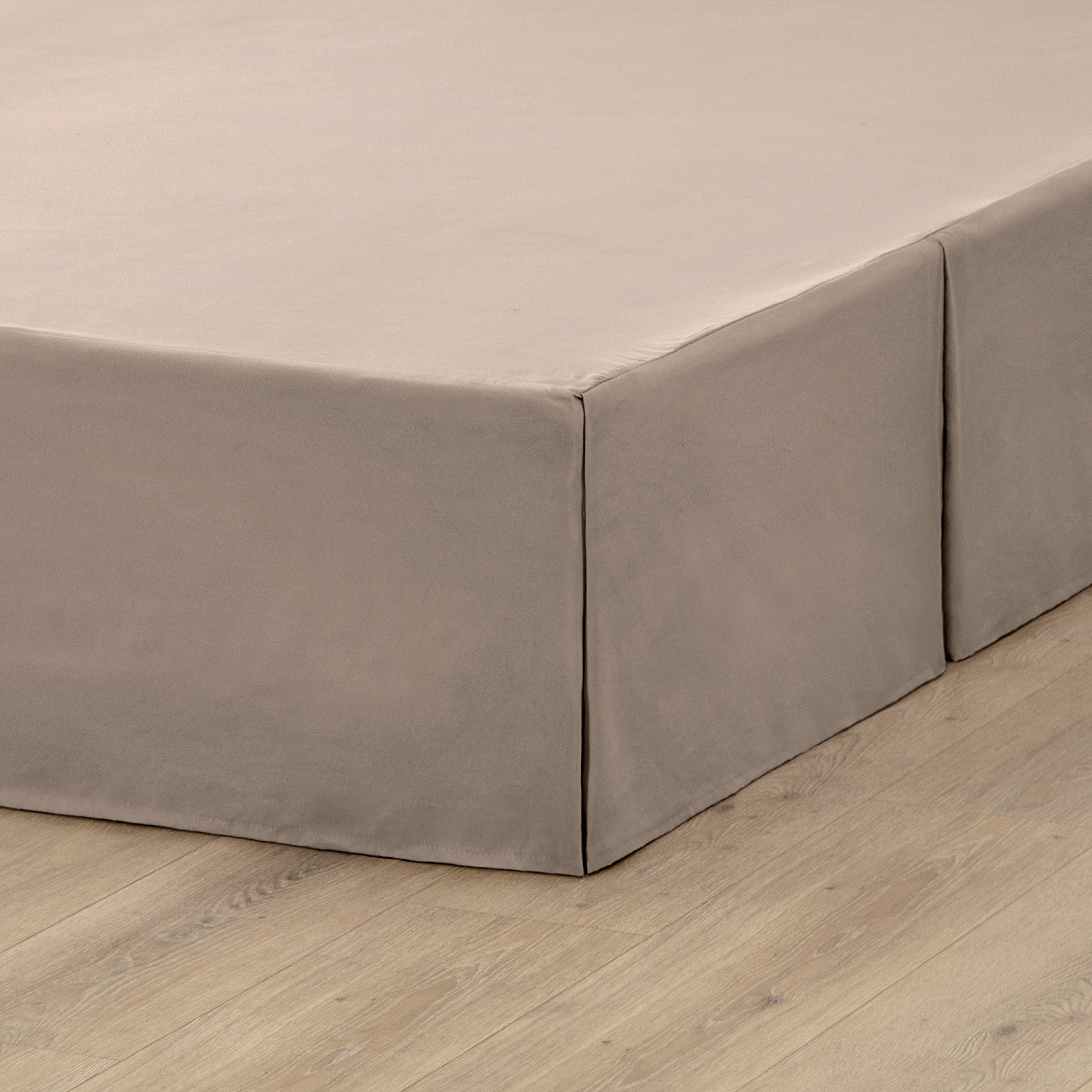 A box spring with a bed skirt on it