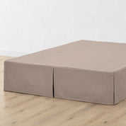 A bed skirt draped over a box spring