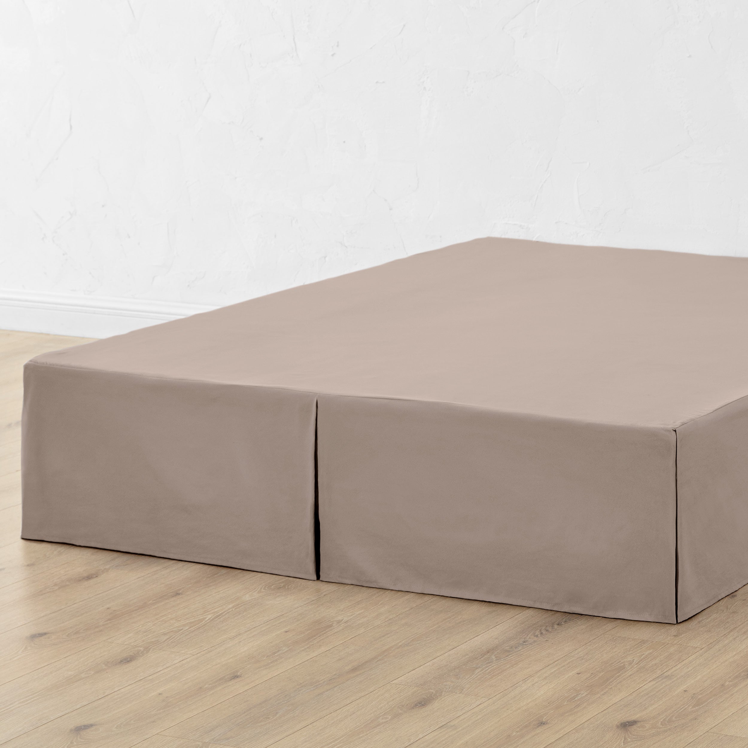 A bed skirt draped over a box spring