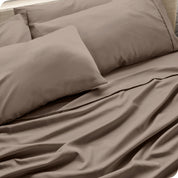 Close up of the microfiber bed sheets on a bed with four pillows.
