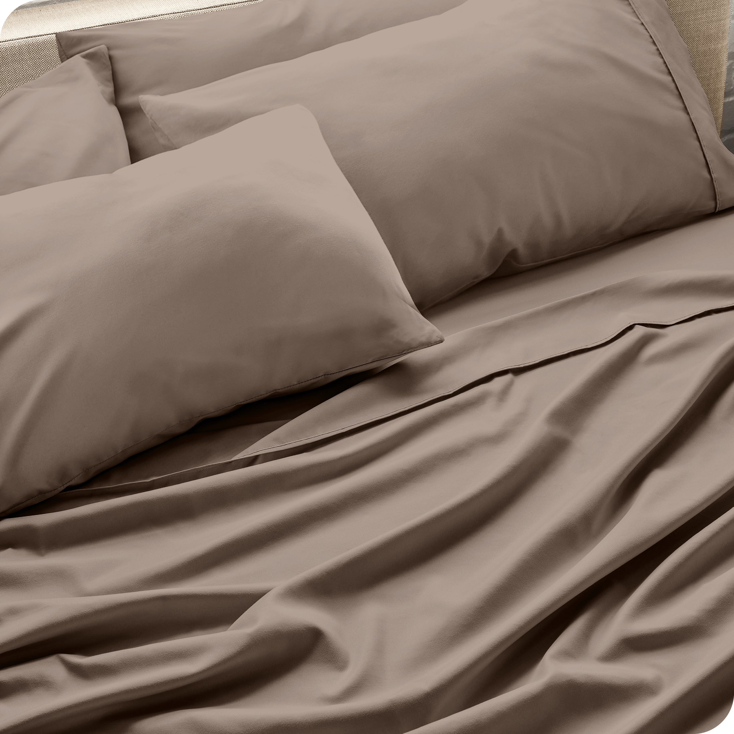 Close up of the microfiber bed sheets on a bed with four pillows.