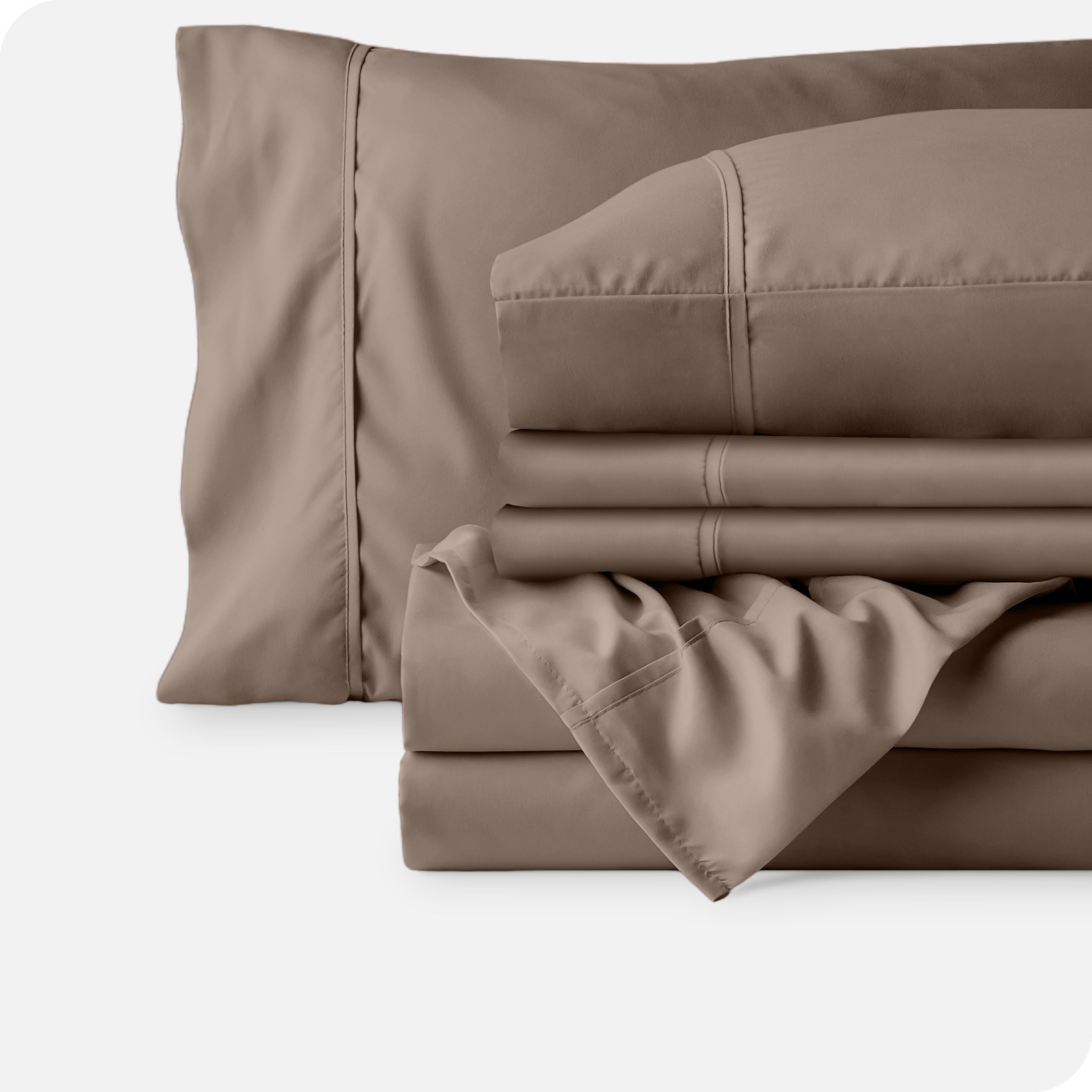 Microfiber sheets neatly folded with corner draped over, two folded pillowcases and two display pillows.
