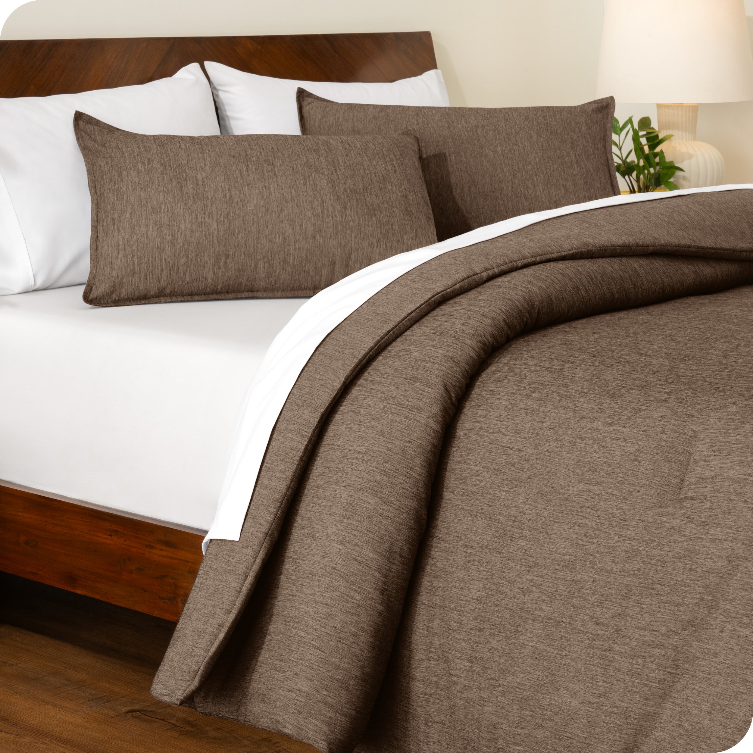 A side view of a modern bed with a comforter set and pillow shams on the bed
