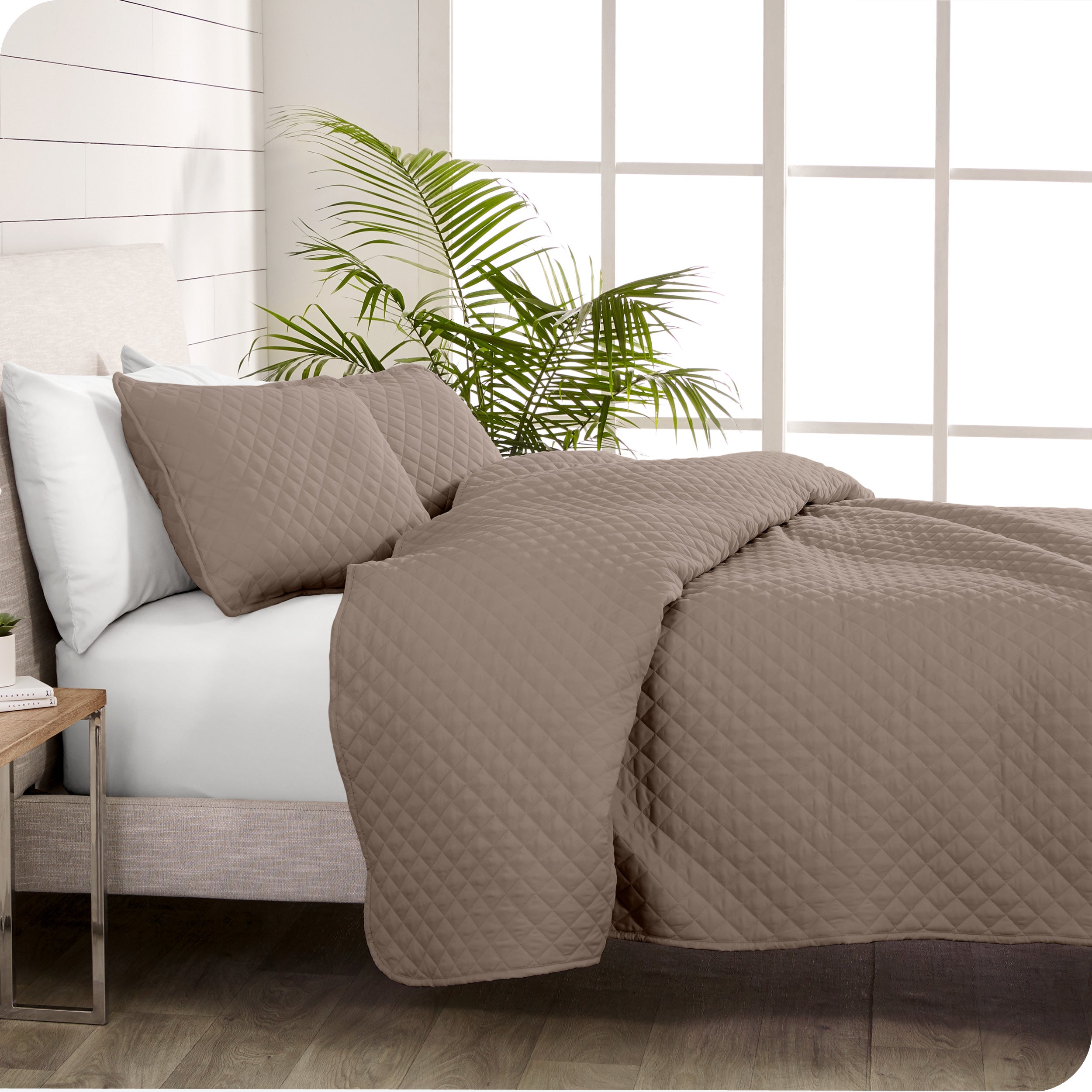 A coverlet set on a bed next to a window
