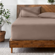 A modern bed with a fitted microfiber sheet made on the mattress. 