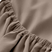 A close up of the elastic of a microfiber fitted sheet. 