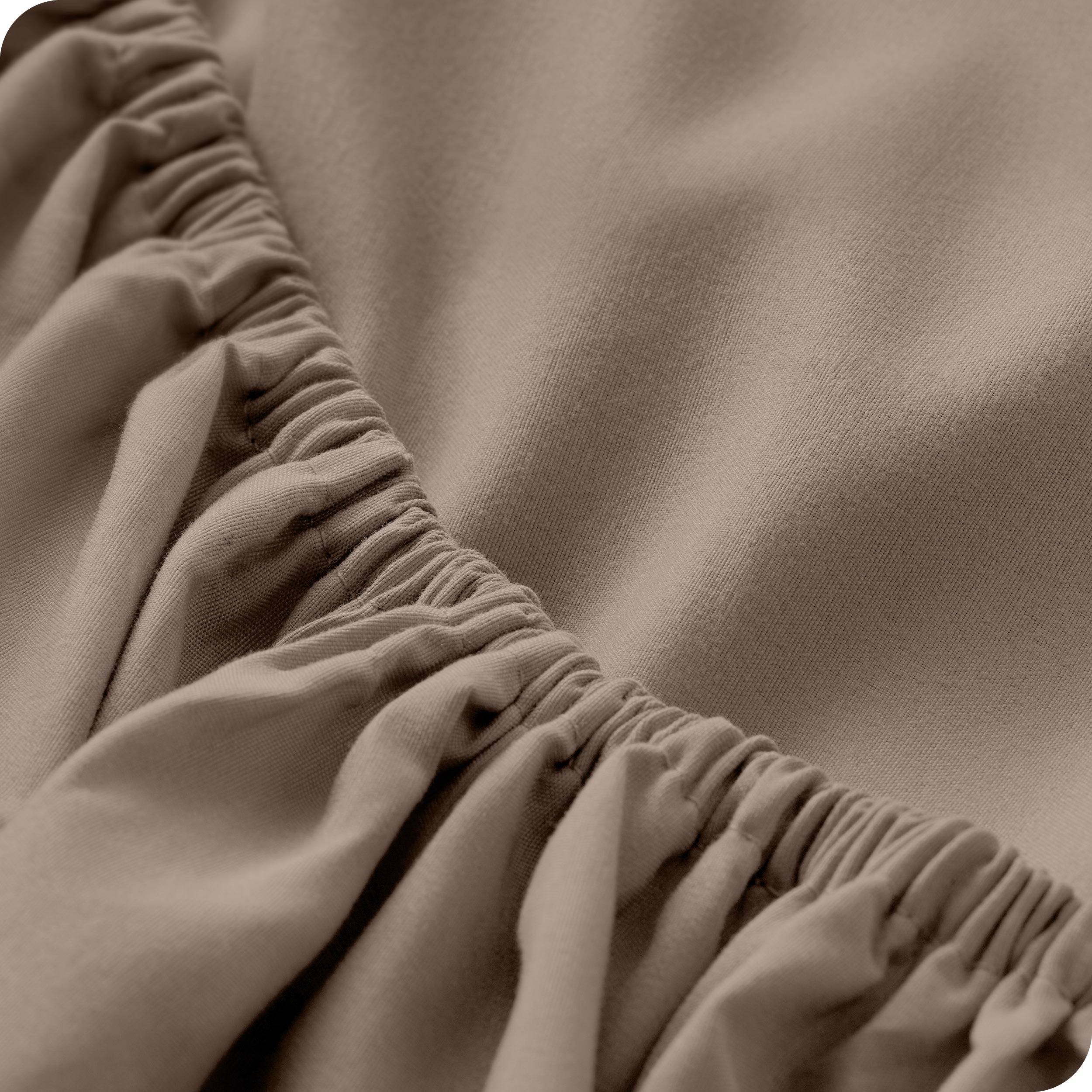 A close up of the elastic of a microfiber fitted sheet. 