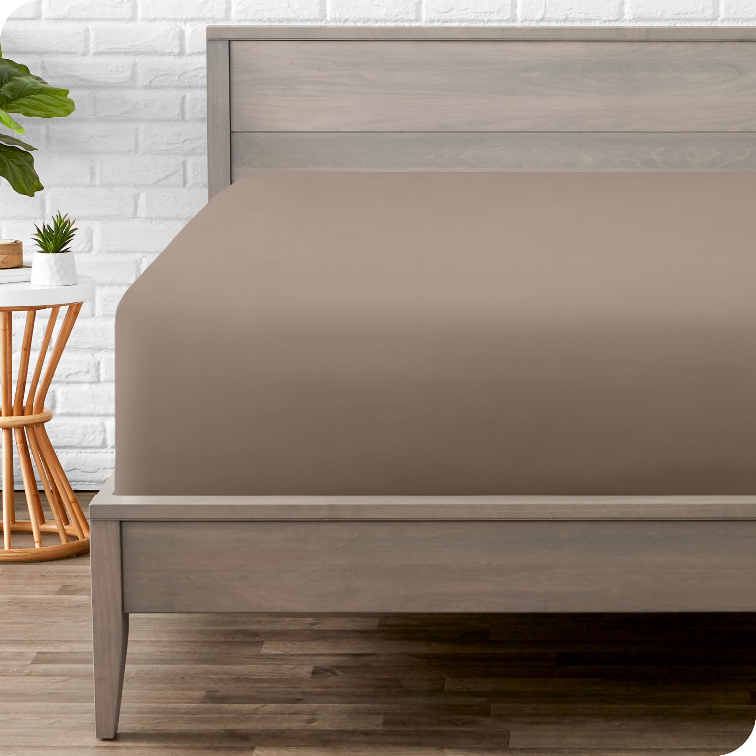 A modern bed with a fitted microfiber sheet on it