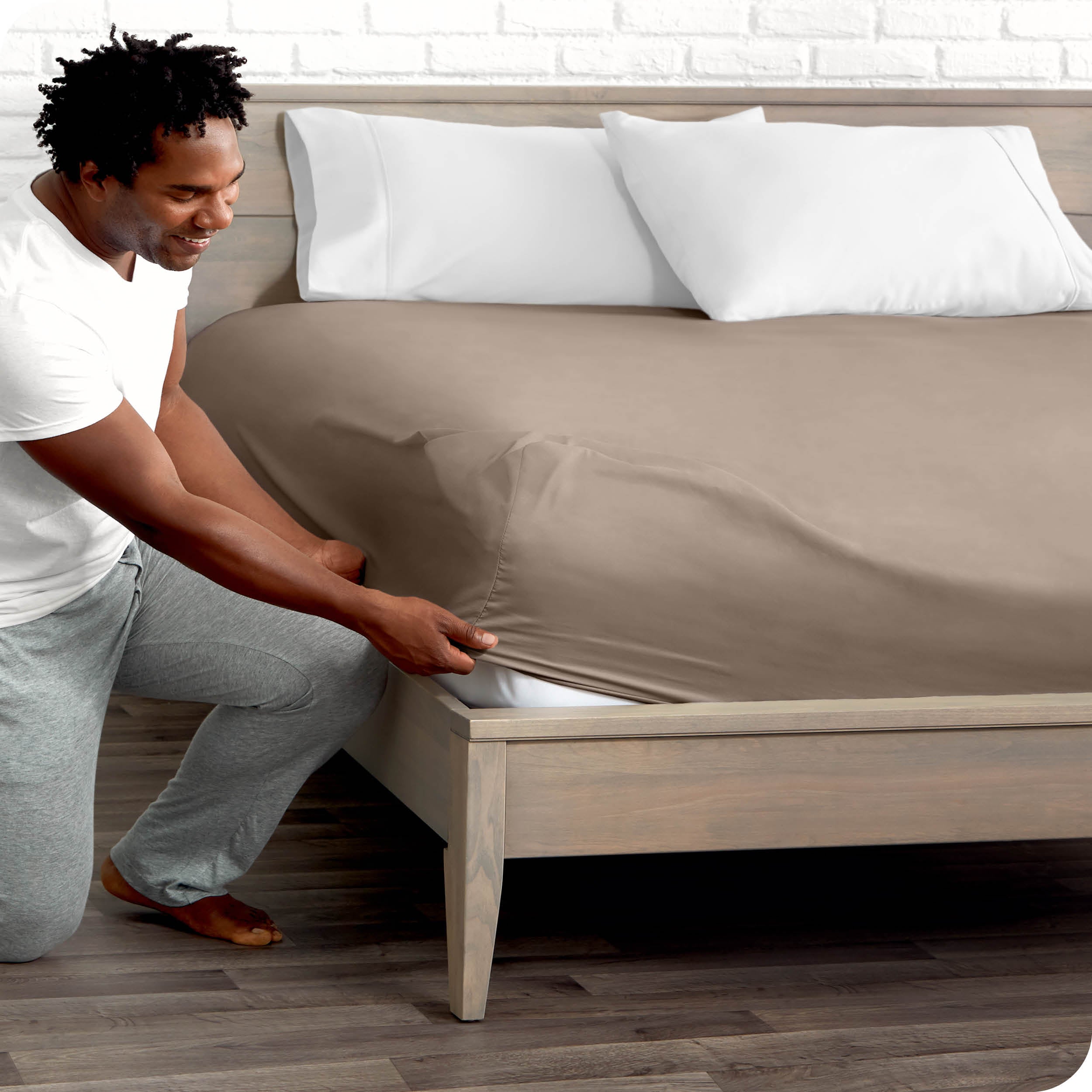 A man putting the microfiber fitted sheet on a mattress. 