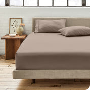 Percale fitted sheet on a mattress with matching pillowcases on pillows